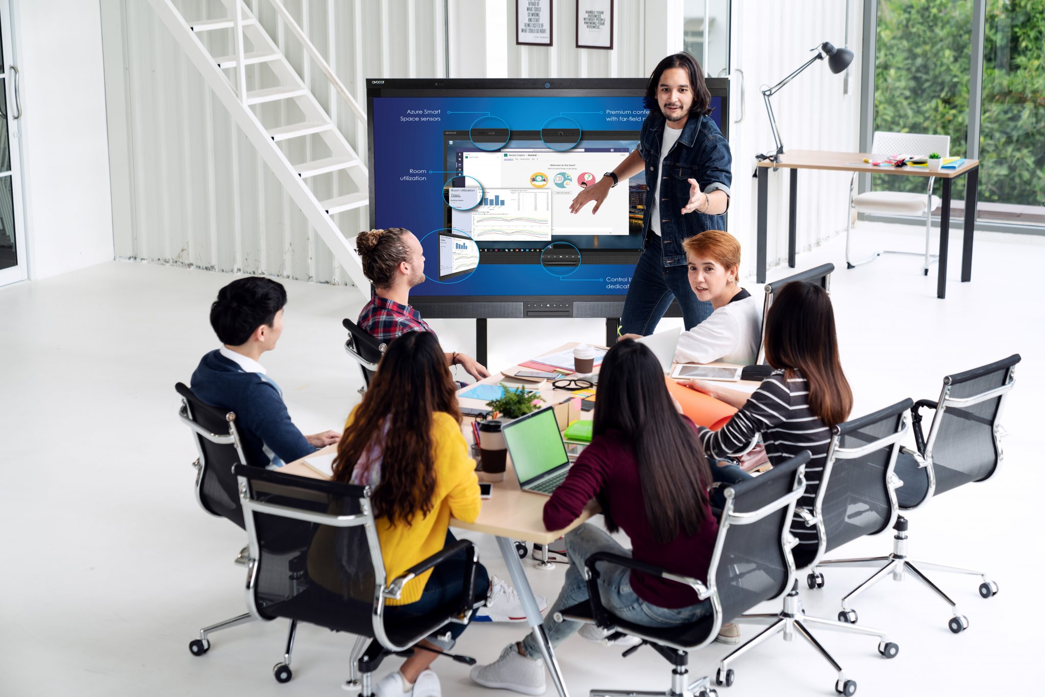 Young asian creative man standing and making presentation at modern office happy talking and brainstorming with team. Casual multiethnic diverse people business meeting concept with rear view.